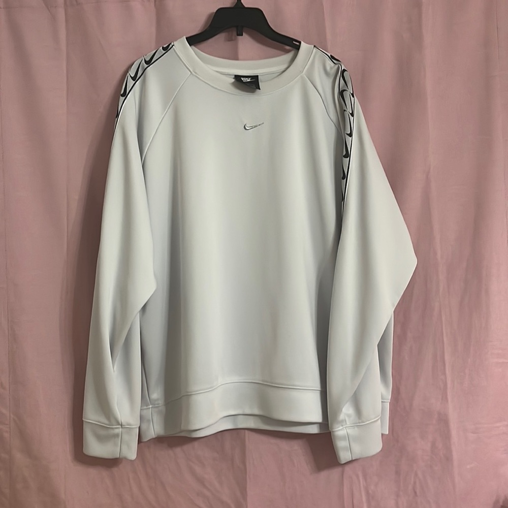 White Nike top with silver Nike swoosh and black swoosh pattern on both sleeves